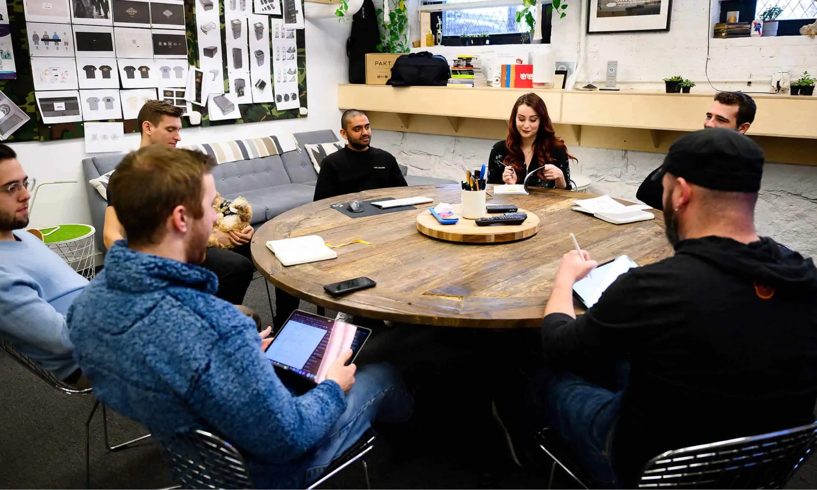 Group of designers brainstorming around a table at Sprout Studios